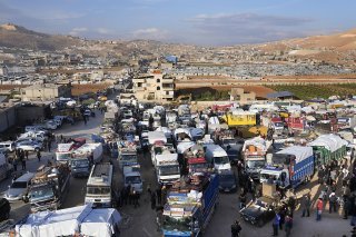 Des camions pleins d'effets de réfugiés syriens attendent de franchir la frontière pour entrer en Syrie depuis la ville libanaise d'Arsal.
